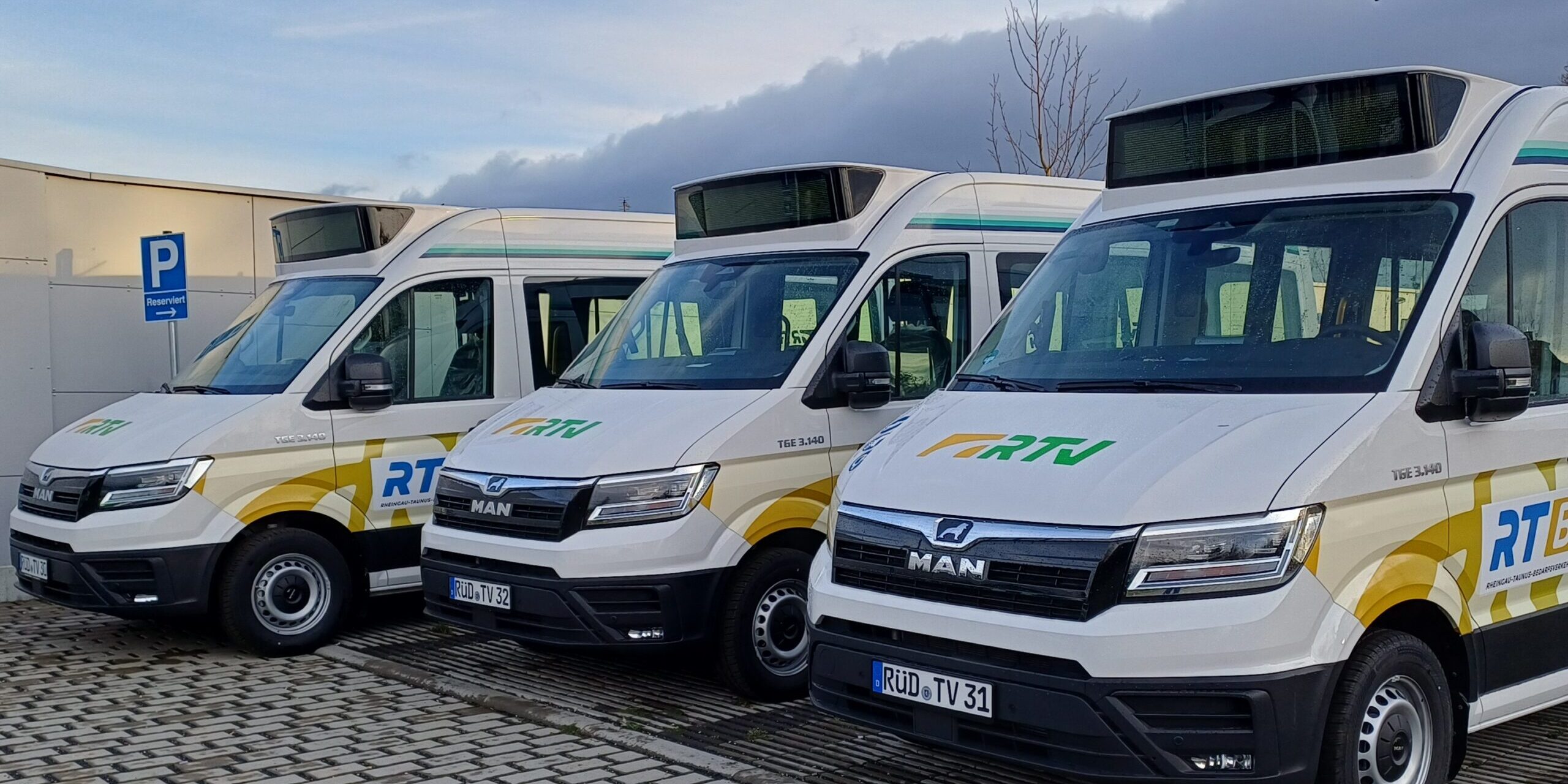 Illustration eines weißen Kleinbusses mit grüner „RTV“-Beklebung vor einer stilisierten Hügellandschaft. Darüber steht das Logo „Taunus FLEX“ in grün-gelber Schrift.
